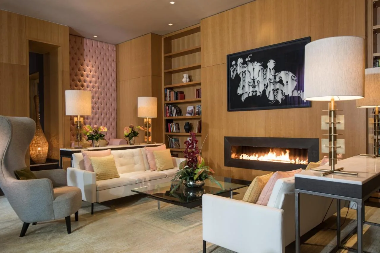 a living room with a couch and a fireplace at The Fitzwilliam Hotel Belfast in Belfast