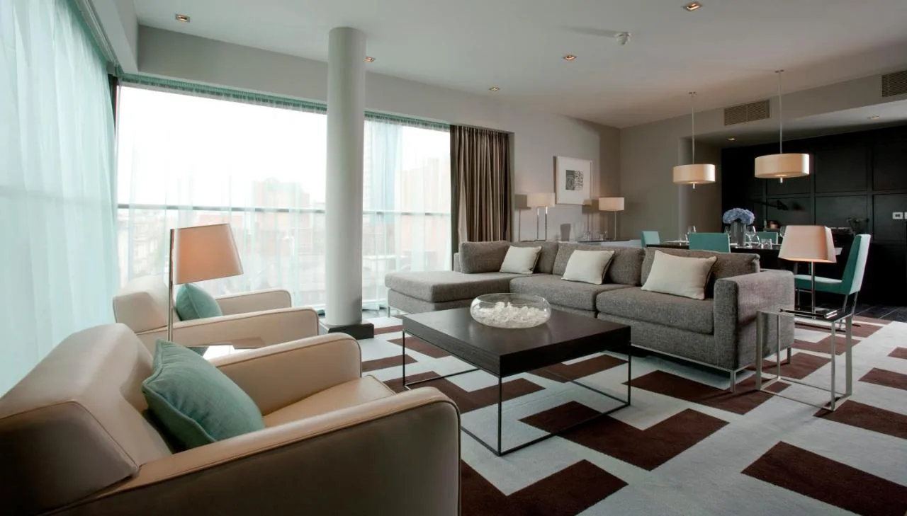 a living room with two couches and a table at The Fitzwilliam Hotel Belfast in Belfast